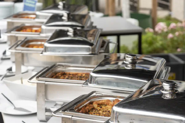 Close-up of a buffet table at the Social Event with chafing dishes.